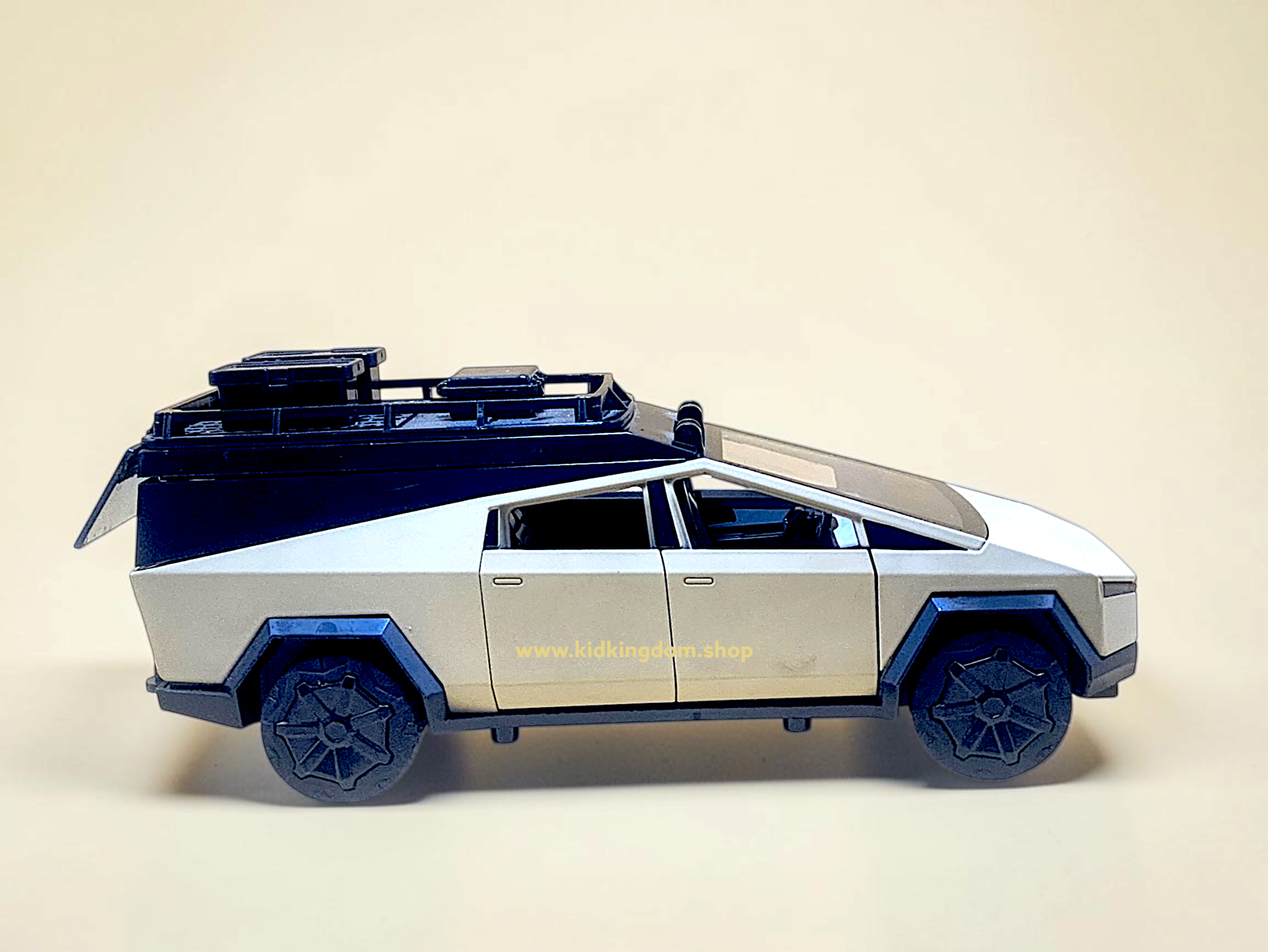 Side profile of silver diecast camper van with lifted roof exposing bed and lounge area