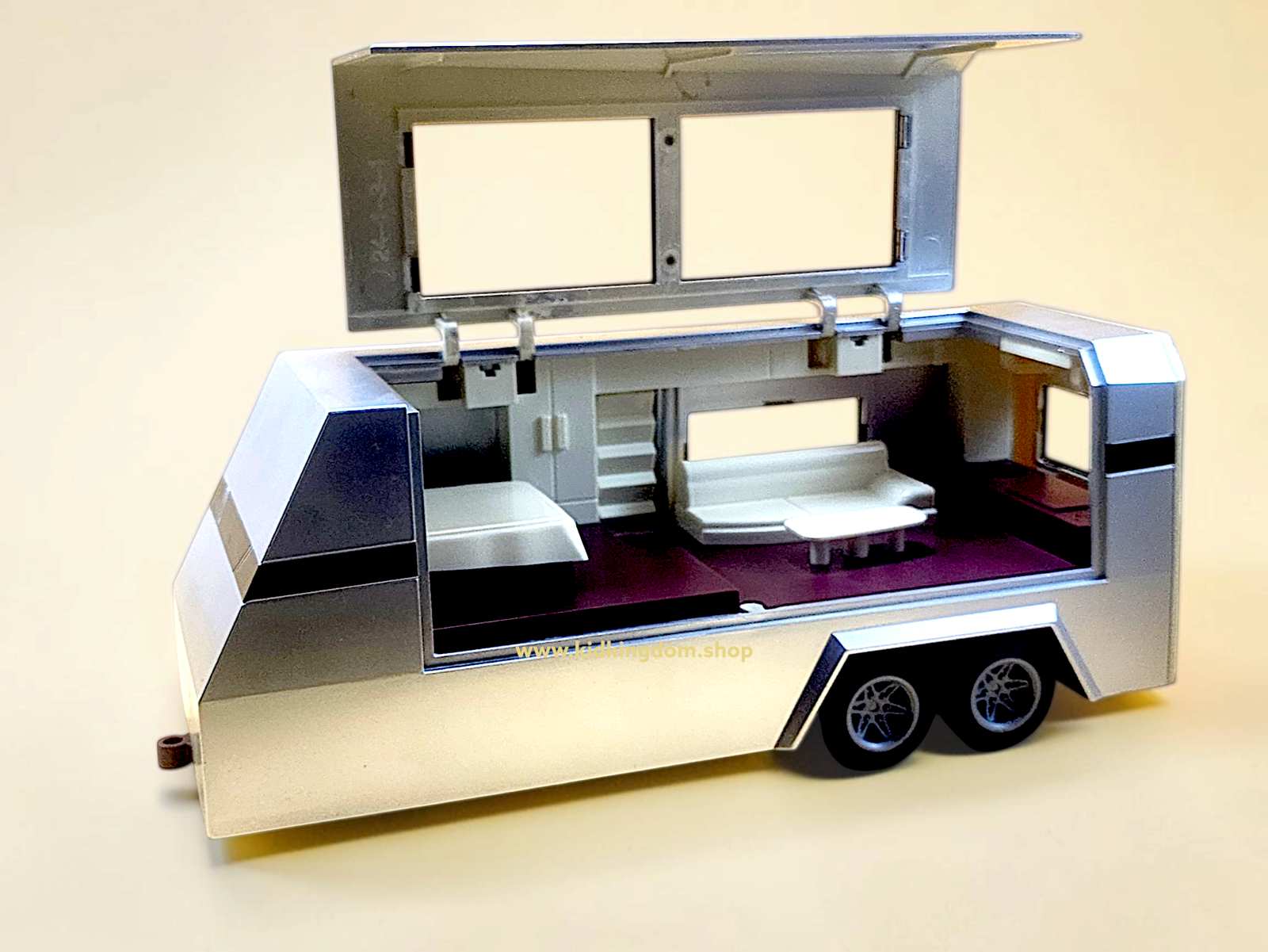 White diecast cyber truck towing luxury camper trailer with open roof setup for kids