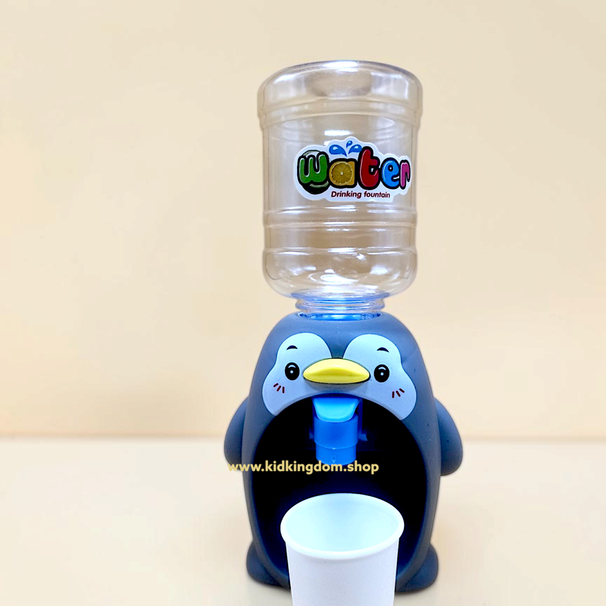 Close-up of the push-button water tap and bottle connection on the penguin dispenser toy