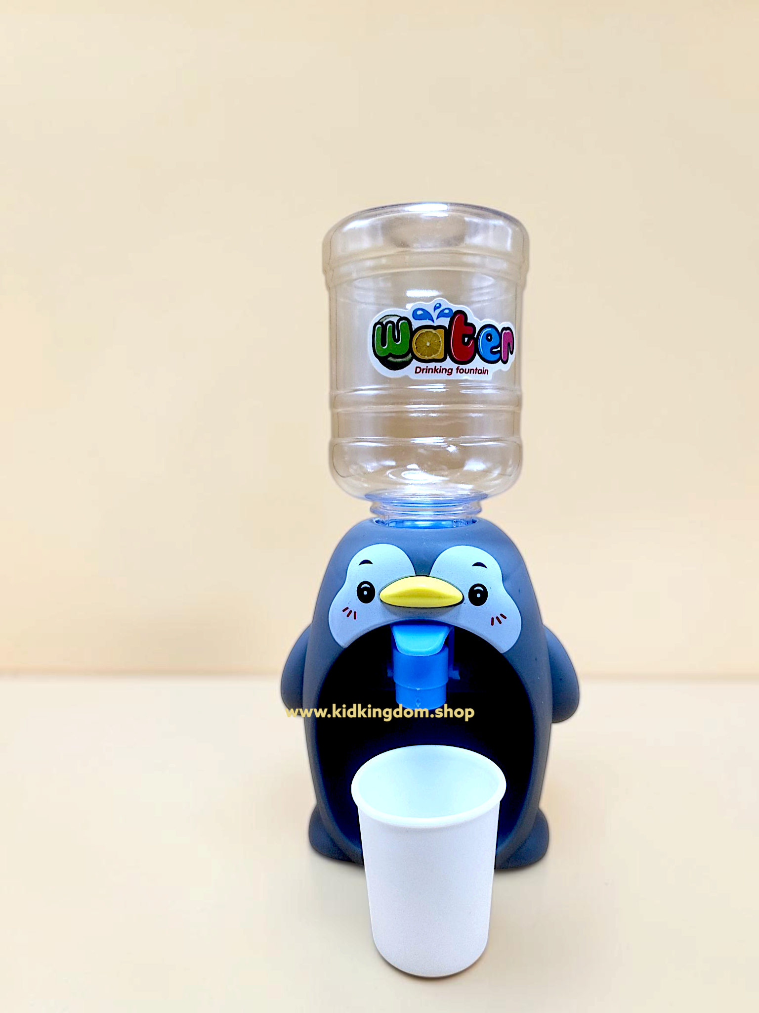 Close-up of the push-button water tap and bottle connection on the penguin dispenser toy