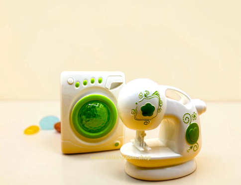 Close-up of toy front-load washing machine showing green circular door and control dials