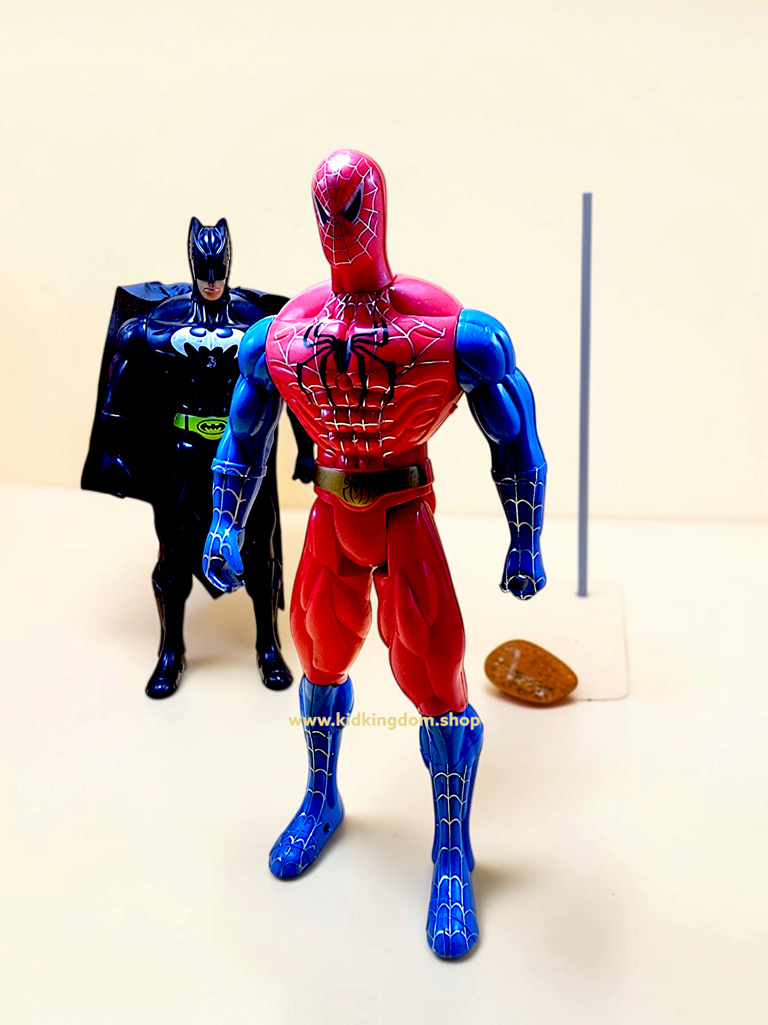 Close-up of superhero action figure chest emblem showing the light-up button feature